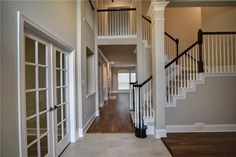 Two-story entry with French doors and a staircase