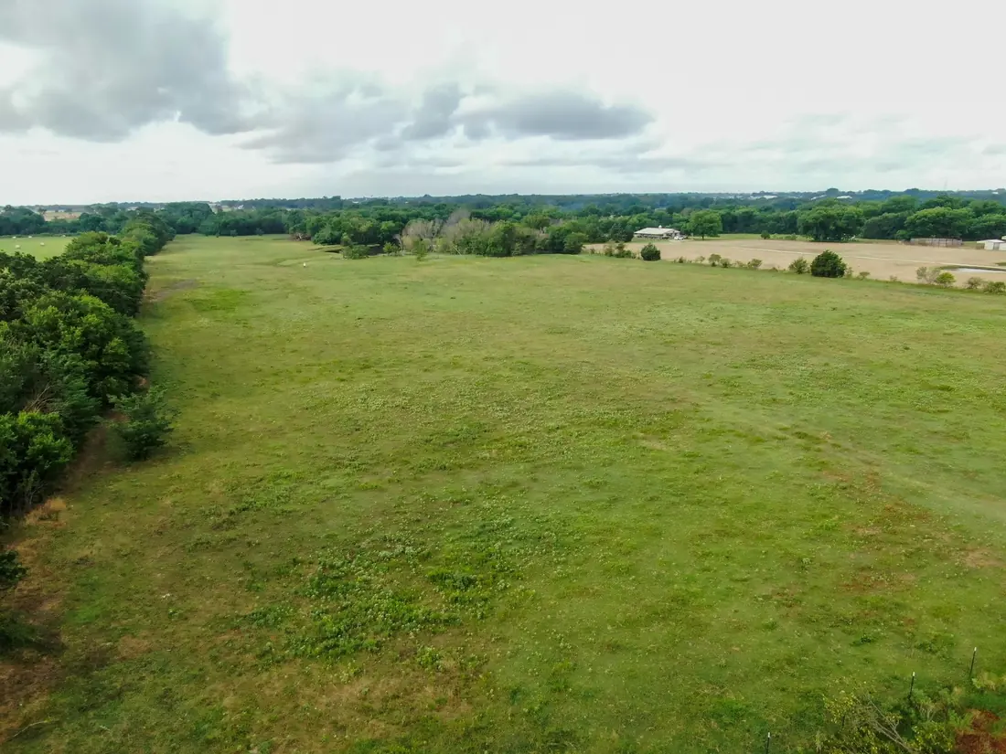 Open green acreage under a wide sky in Pilot Point